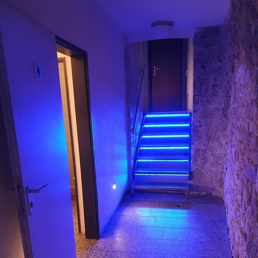Blue lit stairs, door and wall.